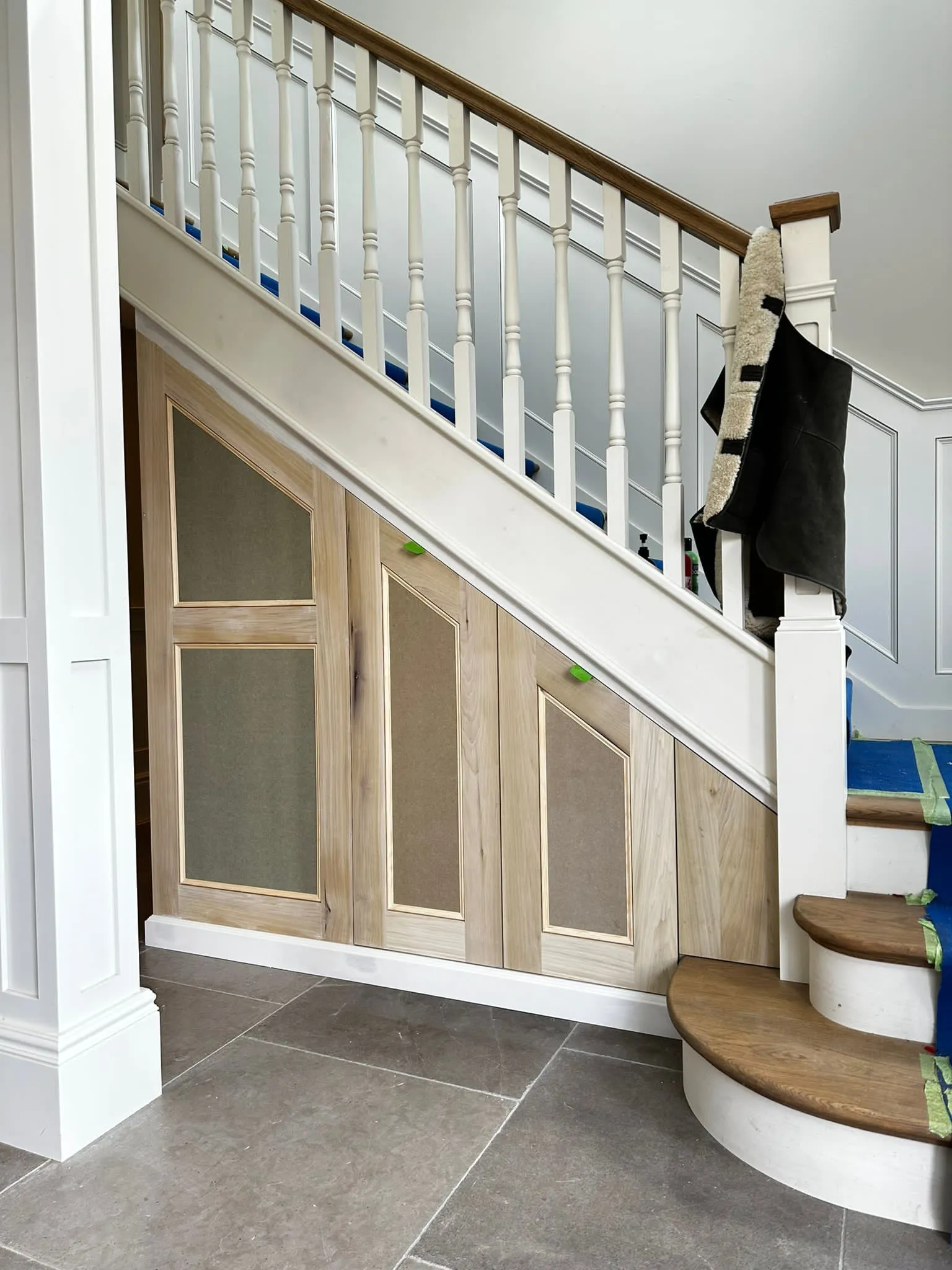 a stair case with a coat rack and a coat hanging on it