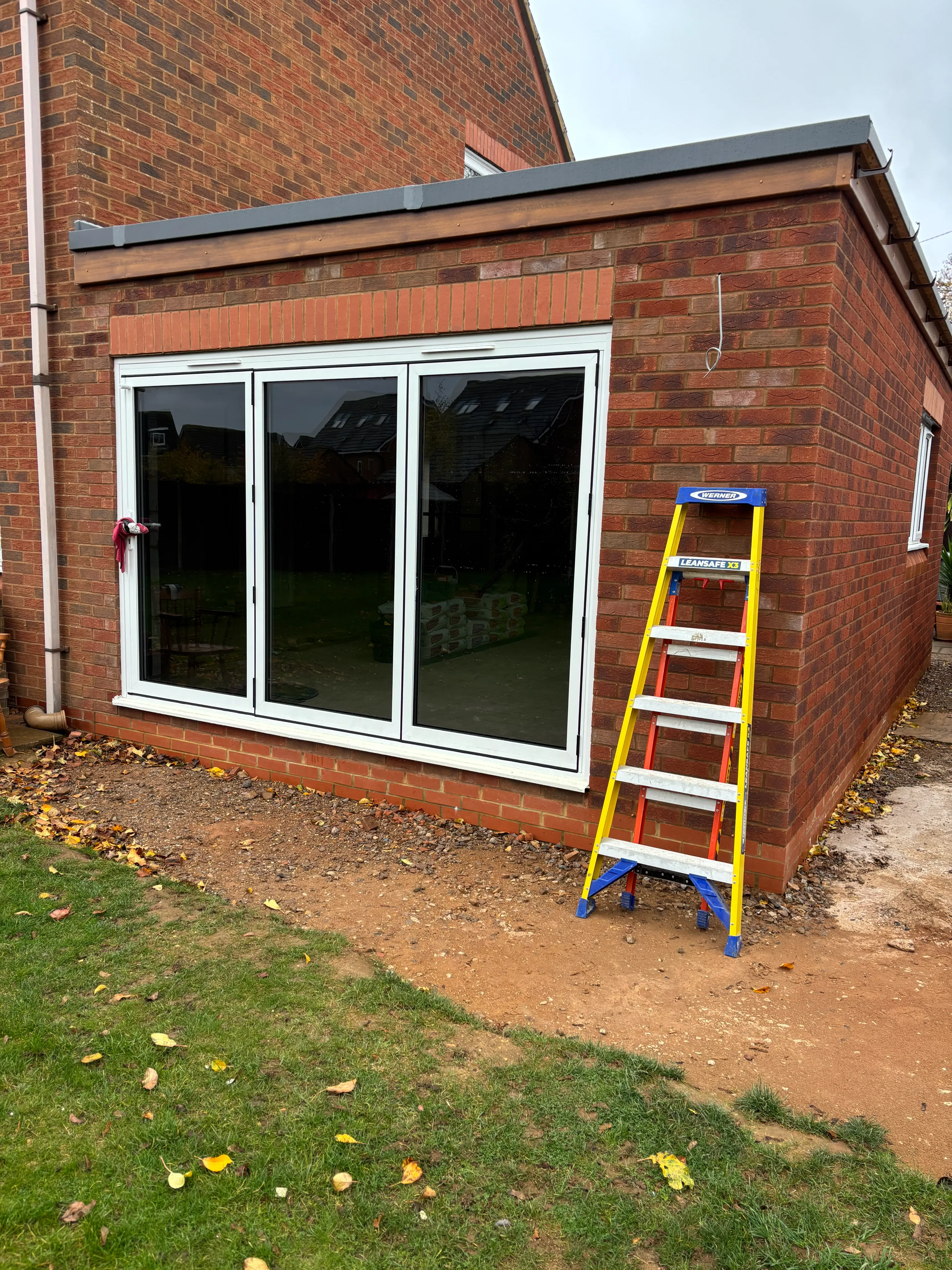 A yellow ladder leaning against a brick building.