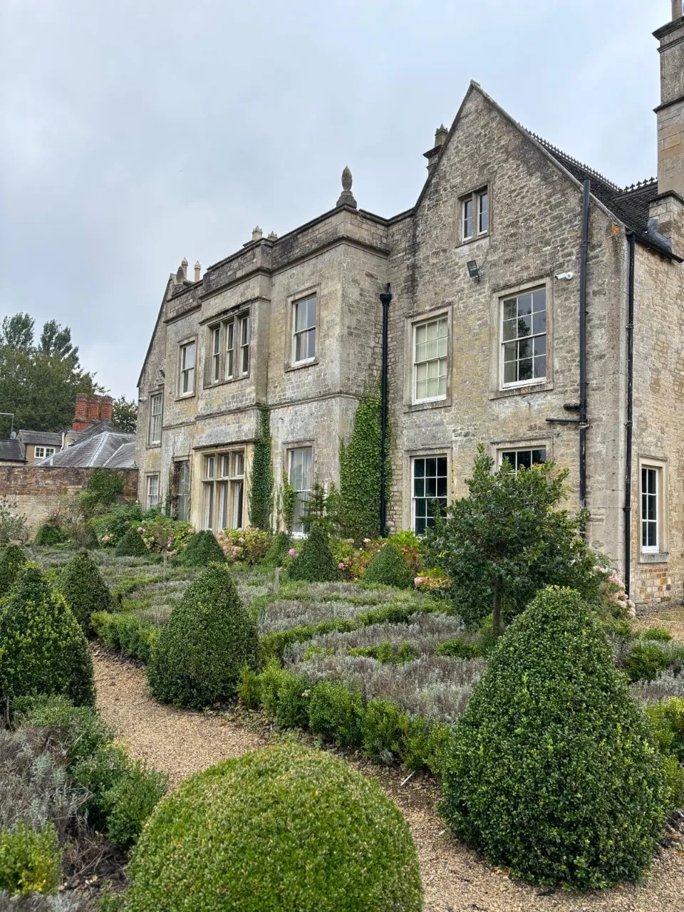 A large stone building with a garden in front of it.