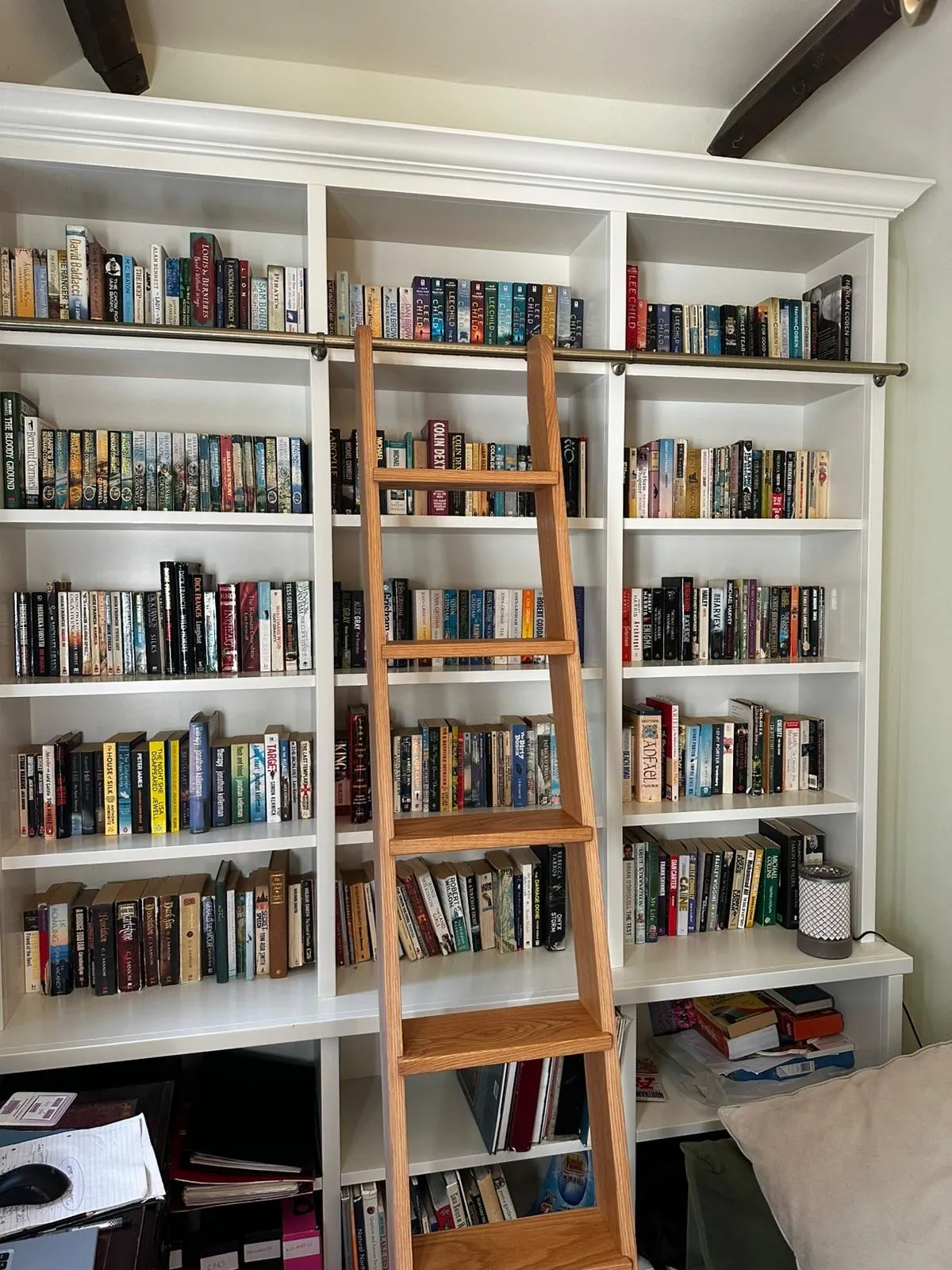 A ladder leaning against a bookshelf filled with books.